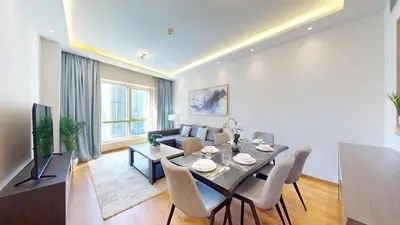 a living room with a dining table and a couch at Vacationer l Glamorous 2 Bedroom l Stunning Lake View l Free Wi-Fi in Dubai