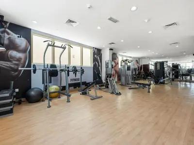 a gym with weights and equipment in a room at Vacationer l Glamorous 2 Bedroom l Stunning Lake View l Free Wi-Fi in Dubai