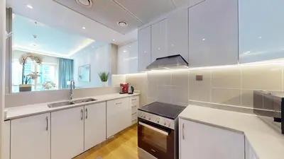 a kitchen with white cabinets and a sink and a stove at Vacationer l Glamorous 2 Bedroom l Stunning Lake View l Free Wi-Fi in Dubai