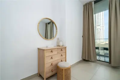 a bedroom with a dresser and a mirror at Waterfront Living Bright 1 Bedroom Marina in Dubai