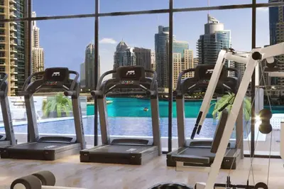 a gym with exercise equipment and a view of the city at Waterfront Living Bright 1 Bedroom Marina in Dubai