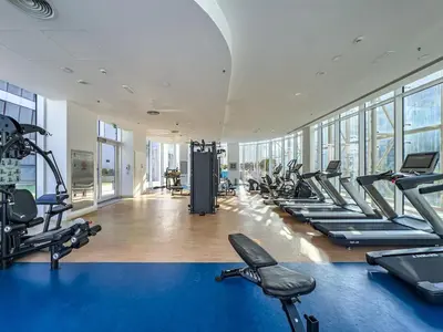 a gym with a bunch of treadms and cardio machines at Deluxe 1BR Business Bay - with Canal and Skyline Views in Dubai