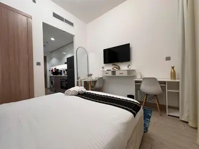 a bedroom with a bed and a desk with a television at Ramora Homes Azizi Riviera 40 by Vacay Xeal in Dubai