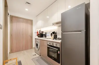 a kitchen with a stainless steel refrigerator and a dishwasher at Ramora Homes Azizi Riviera 40 by Vacay Xeal in Dubai