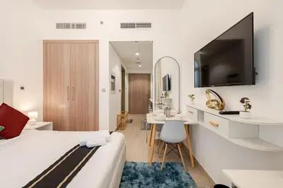 a hotel room with a bed and a desk and a tv at Ramora Homes Azizi Riviera 40 by Vacay Xeal in Dubai