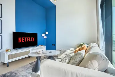 a living room with a white couch and a tv at Modern 1BR Urban Escape at Blue Paradise in Dubai