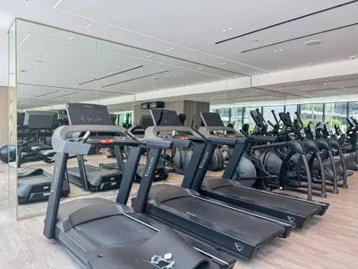 a gym with a row of treadmills and ellipticals at Modern 1BR Urban Escape at Blue Paradise in Dubai