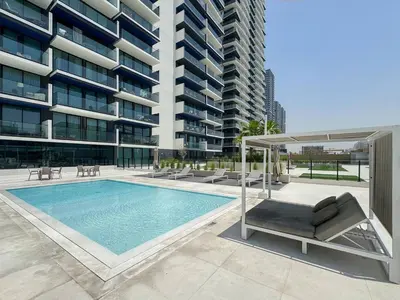 a swimming pool in front of a tall building at Modern 1BR Urban Escape at Blue Paradise in Dubai