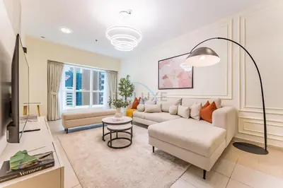 a living room with a couch and a table at Sky-Level 2BR with Partial Marina View, Just Steps to Dubai Tram and Minutes from the Beach, Elite Residence, Dubai Marina by Deluxe Holiday Homes in Dubai