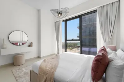 a white bedroom with a large bed and a large window at 2BR with M CF7B Partial Canal View in Dubai