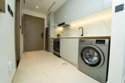 a laundry room with a washing machine in a kitchen at AWS Holiday Homes - Iconic Burj Khalifa Views in Dubai