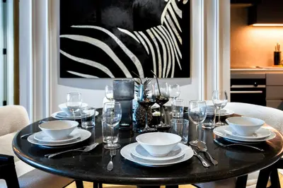 a black table with plates and wine glasses on it at Exclusive 2BD in JBR Address with Ain Dubai View in Dubai