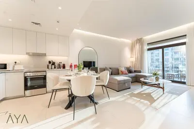a kitchen and living room with a table and chairs at Chic 1BR Apartment near Madinat Jumeirah BurjAlArab in Dubai