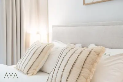 a white bed with white pillows on it at Chic 1BR Apartment near Madinat Jumeirah BurjAlArab in Dubai