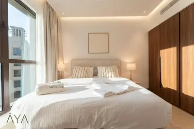 a white bed in a bedroom with a large window at Chic 1BR Apartment near Madinat Jumeirah BurjAlArab in Dubai