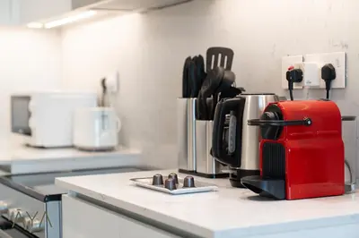 a kitchen counter with a red coffee maker on it at Chic 1BR Apartment near Madinat Jumeirah BurjAlArab in Dubai