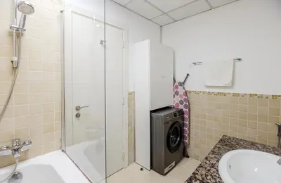 a bathroom with a washing machine in a shower at Spacious and luxurious studio with amazing marina view!Rimal ! in Dubai