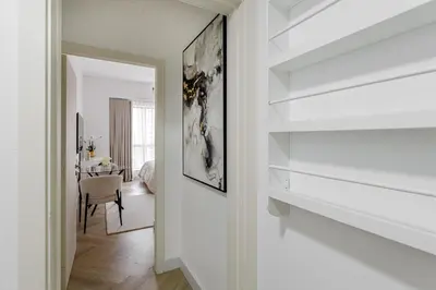 a hallway with white walls and a dining room at Spacious and luxurious studio with amazing marina view!Rimal ! in Dubai