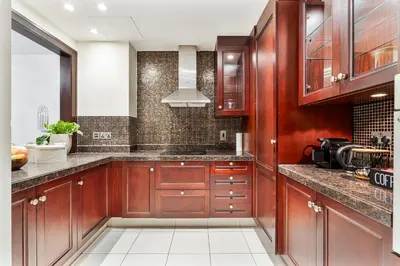 a kitchen with wooden cabinets and marble counter tops at 2BHK Downtown Breathtaking Burj Khalifa View in Dubai
