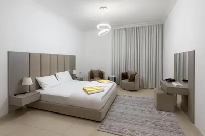 a white bedroom with a bed and a tv at The Rosewood HH at Sarai Residence, Palm Jumeirah, 5 mins from the Iconic Atlantis The Royale in Dubai