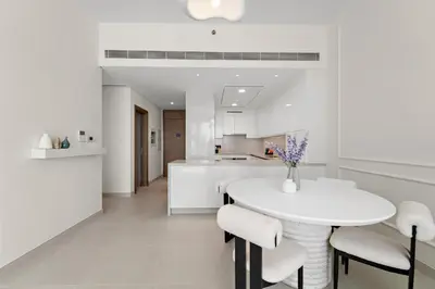 a white kitchen with a white table and chairs at 2BR with M CF7B Pet Friendly Stay in Dubai