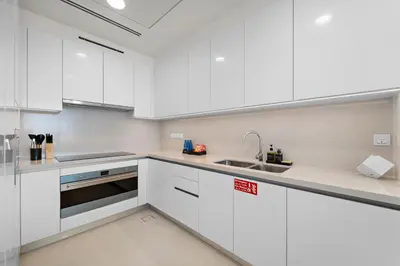 a white kitchen with white cabinets and a sink at 2BR with M CF7B Pet Friendly Stay in Dubai