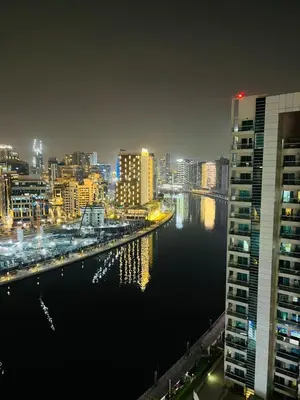 a city skyline at night with a river and buildings at Bussinss bay in Dubai