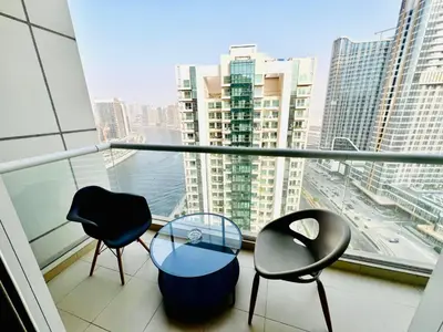 a balcony with two chairs and a glass table at Bussinss bay in Dubai