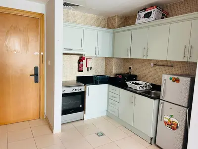 a kitchen with white cabinets and a white refrigerator at Bussinss bay in Dubai