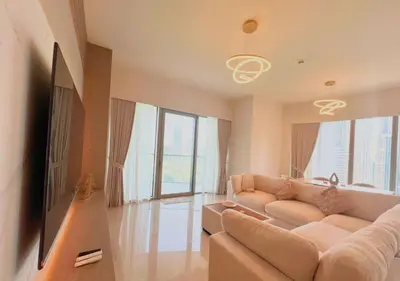 a living room with a couch and a flat screen tv at DreamShoma Grande Signature Luxury Full Burj Khalifa & Fountain View in Dubai