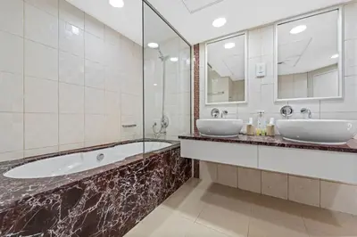 a bathroom with two sinks and a tub and mirrors at Duplex 2BR next to Marina Beach in Dubai