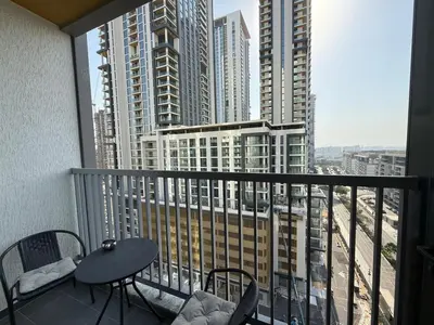 a balcony with a table and chairs and a view of a city at Elegant 1-Bedroom The Crest, Near Downtown Dubai in Dubai