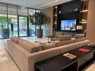 a living room with a large couch and a tv at Elegant 1-Bedroom The Crest, Near Downtown Dubai in Dubai