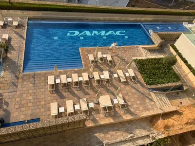 a swimming pool with a bunch of chairs in front of it at Family Stay in Downtown 2BR Sleeps 6 Burj View in Dubai