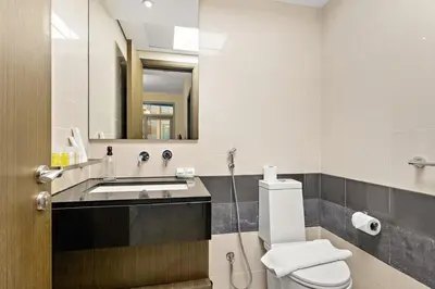 a bathroom with a sink and a toilet and a mirror at FIRST CLASS 1BR Central Dubai Luxury Living in Dubai