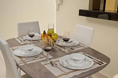 a table with plates and glasses of wine on it at FIRST CLASS 1BR Central Dubai Luxury Living in Dubai