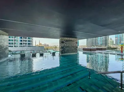 a large swimming pool with a view of a city at FIRST CLASS 3BR Elegant Comfort , Lake Views in Dubai