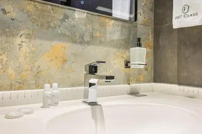 a bathroom sink with a faucet and soap bottles at FIRST CLASS 3BR Elegant Comfort , Lake Views in Dubai