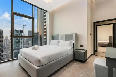 a bedroom with a large bed and a large window at FIRST CLASS 3BR Elegant Comfort , Lake Views in Dubai