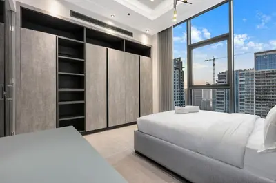 a bedroom with a white bed and a large window at FIRST CLASS 3BR Elegant Comfort , Lake Views in Dubai