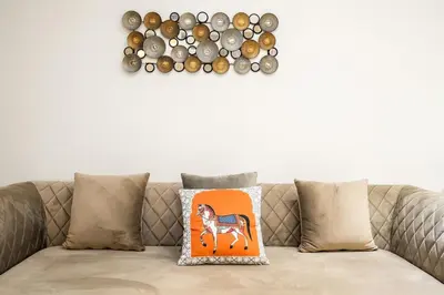 a cushion on a couch with a horse on the wall at FIRST CLASS 2BR Luxury Marina Bliss in Dubai