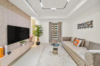 a living room with a couch and a flat screen tv at FIRST CLASS 2BR Luxury Marina Bliss in Dubai