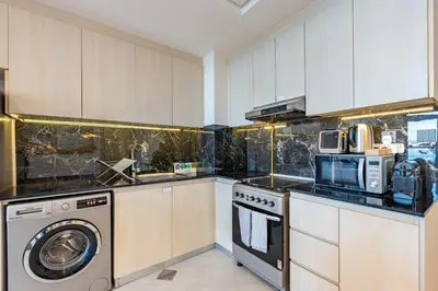 a kitchen with a washing machine and a washer at Spacious Balcony with Breathtaking Creek Views, Just a Short Drive from Zabeel Stadium, Al Jaddaf Walk, and Cactus Park, Binghatti Avenue, Al Jaddaf by Deluxe Holiday Homes in Dubai