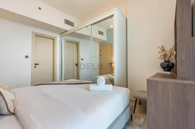 a bedroom with a white bed and a large mirror at Spacious Balcony with Breathtaking Creek Views, Just a Short Drive from Zabeel Stadium, Al Jaddaf Walk, and Cactus Park, Binghatti Avenue, Al Jaddaf by Deluxe Holiday Homes in Dubai