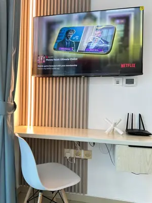 a tv on a wall with a desk and a chair at Minimalist Studio with Amazings Marina Canal Views in Dubai