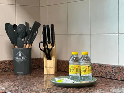 a counter with two bottles of water and a container of scissors at Minimalist Studio with Amazings Marina Canal Views in Dubai