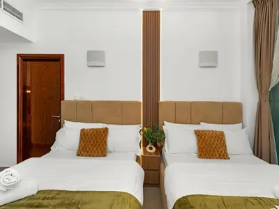 two beds sitting next to each other in a room at Centric Flat w Marina View, Ideal Beach Stay Big Terrace Sleep 9 in Dubai