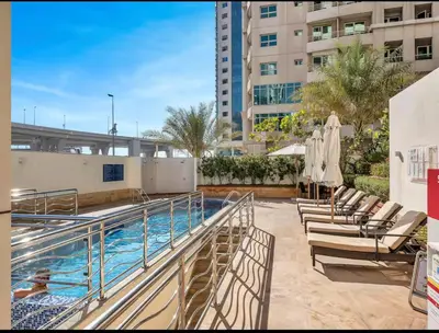 a swimming pool with chaise lounge chairs next to a building at Centric Flat w Marina View, Ideal Beach Stay Big Terrace Sleep 9 in Dubai