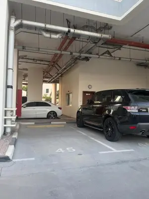a parking lot with two cars parked in a garage at Specious 1 bd close to Sea Jumeirah in Dubai