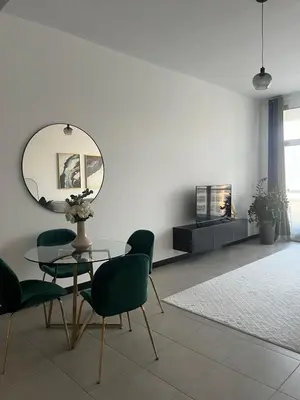 a dining room with a table and chairs and a mirror at Specious 1 bd close to Sea Jumeirah in Dubai